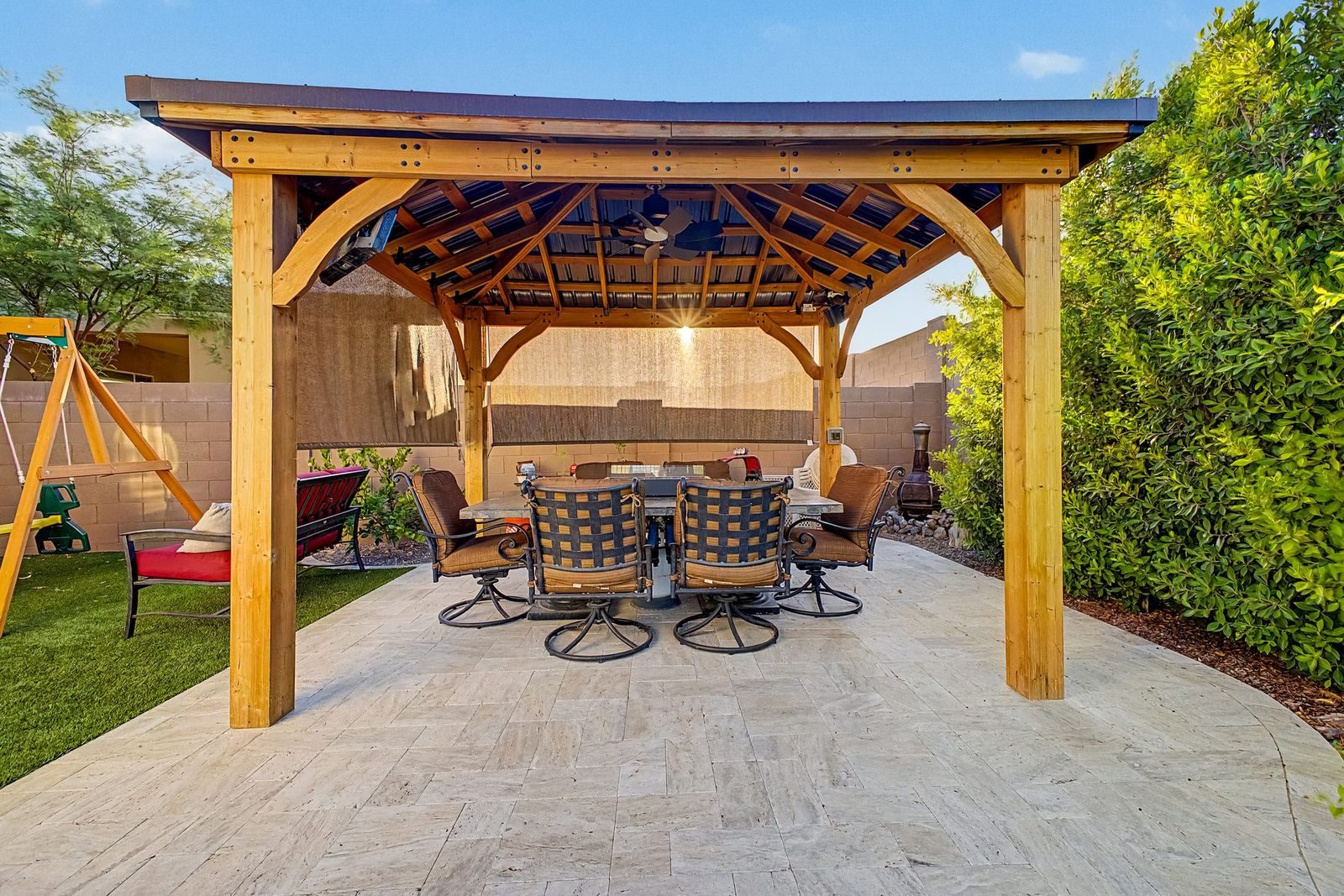 Cedar gazebo with dining set in a green backyard